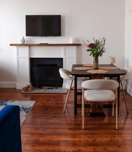 a dining room with a table and a fireplace at Sand In My Shoes in Muizenberg