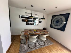 a dining room with a table and stools at Maison avec piscine proche de Paris in Groslay