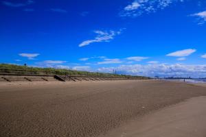 an empty beach with a blue sky and the ocean at Crosby & Waterloo Beachside Stay in Waterloo +10 photos