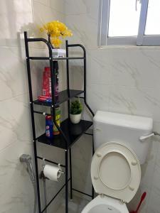 a bathroom with a toilet with a shelf next to it at The Wink apartments in Malindi +15 photos