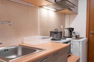 a kitchen with a sink and a stove at Rosso 3 City Centre Apartment in Heraklio
