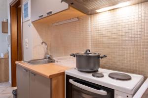 a kitchen with a pot on a stove with a sink at Rosso 3 City Centre Apartment in Heraklio +31 photos