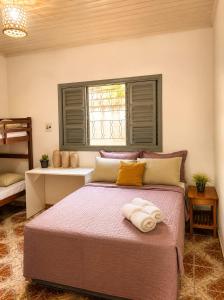 a bedroom with a bed with two towels on it at Casa de Alter - Hospedaria e Experiências in Alter do Chao