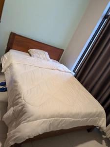 an unmade bed in a room with a window at Star real in Kigali