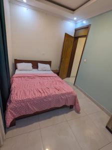 a bedroom with a bed with a red blanket at Star real in Kigali +5 photos