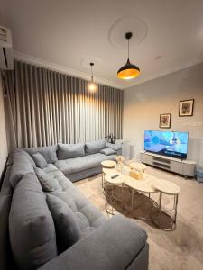 a living room with a large couch and a table at أوبال ستاي المطار in Abha