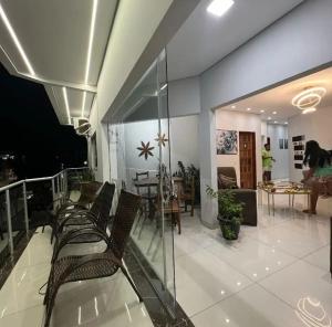 a room with a balcony with chairs and a table at Hotel Lara - Simolândia in Alvorada do Norte 