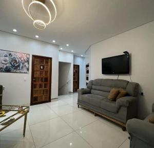 a living room with a couch and a flat screen tv at Hotel Lara - Simolândia in Alvorada do Norte 