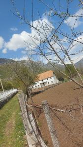 a fence in front of a field with a building at Guest House Avdi Kola in Gagu