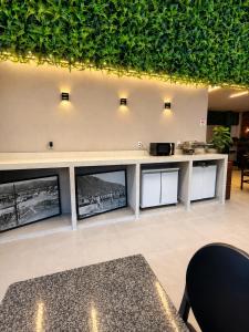 a lobby with a row of framed pictures on the wall at Flamingo Beach Pousada in Cabo Frio