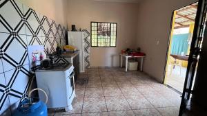 a kitchen with a refrigerator and a tile floor at Casa Lari Hostel in Vila Tepequém