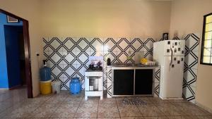 a kitchen with a white refrigerator and a tile wall at Casa Lari Hostel in Vila Tepequém +7 photos
