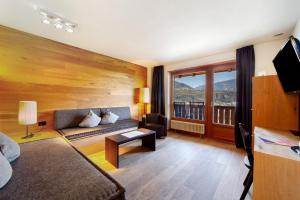 a living room with a couch and a large window at Bio Wellnesshotel Pazeider in Marlengo