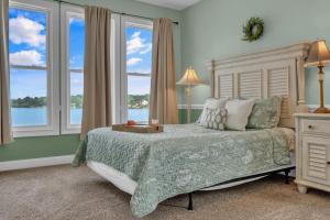 a bedroom with a bed with a view of the water at Lakefront Getaway with Dock, Pool, Sunset Games in Greenwood