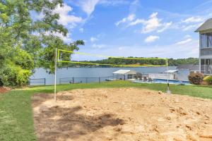 a volleyball net in a yard with a lake at Lakefront Getaway with Dock, Pool, Sunset Games in Greenwood