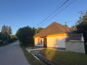 a small yellow and white building on a road at Görbeút Vendégház in Vigántpetend