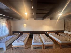 a group of four beds in a room at Görbeút Vendégház in Vigántpetend