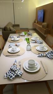 a table with plates and utensils on top of it at Casa Marimar Milagres- Praia do Marceneiro in Passo de Camarajibe