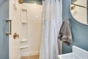 a bathroom with a white shower curtain and a mirror at The Cottage on Corinth in Seneca +13 photos