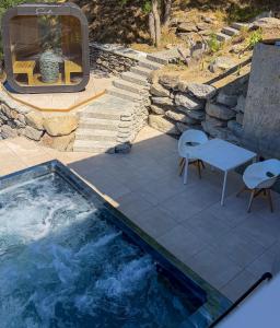 a swimming pool with a table and chairs next to a patio at WOO® Loft Resort in Fiesch