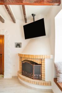 a living room with a fireplace with a flat screen tv at Mythos Villa Above the Sunset in Karpathos