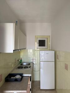 a kitchen with a white refrigerator and a sink at Apartman sa dve spavace sobe, prizemlje, Popović in Petrovac na Moru