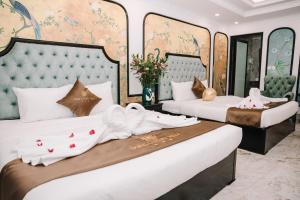 a hotel room with two beds with white sheets at Crown Luxury Hotel in Hanoi