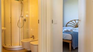 a bathroom with a shower and a sink and a bed at Le Casette a Favignana in Favignana +218 photos