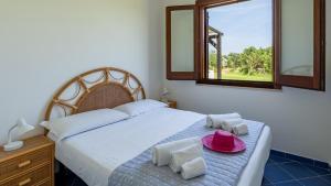 a bedroom with a bed with a hat on it at Le Casette a Favignana in Favignana