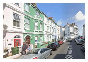 a group of buildings on a street with parked cars at The Loriston in Eastbourne