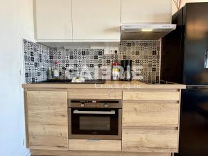 a kitchen with white cabinets and a black oven at GC - Le Panorama - Front de Mer in Wissant