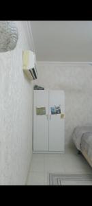 a room with two white cabinets and a bed at صلاله الدهاريز الجنوبيه in Daḩārīz