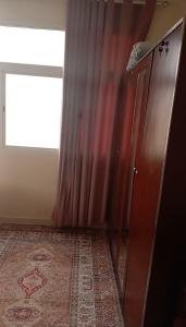 a room with a curtain and a dresser and a window at صلاله الدهاريز الجنوبيه in Daḩārīz