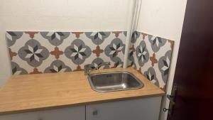 a kitchen with a sink on a wooden counter at Victoria Centre 2BR - Opposite Bus Terminal in Victoria +7 photos