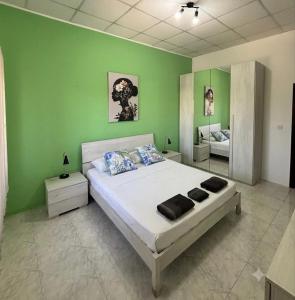 a bedroom with a large bed with a green wall at Victoria Centre 2BR - Opposite Bus Terminal in Victoria