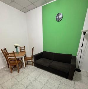 a living room with a couch and a table with a clock at Victoria Centre 2BR - Opposite Bus Terminal in Victoria