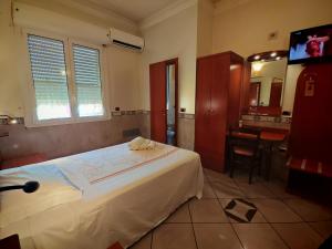 a bedroom with a bed and a bathroom with a sink at Motel Villaggio in Imola