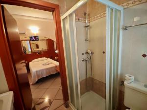 a bathroom with a shower and a bed in a room at Motel Villaggio in Imola +43 photos
