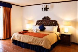 a bedroom with a large bed with two lamps at Ecotel Quinta Regia in Valladolid +88 photos