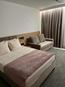 a hotel room with a bed and a couch at No 11 Residence in Krynica Morska