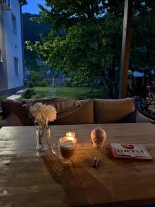 a table with a vase of flowers and candles on it at Kovači Residence in Hrasnica