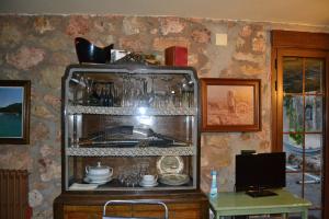 una cocina con una estantería con platos. en La Cabaña de Piedra, en Ruidera