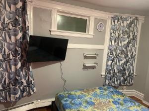 a bedroom with a flat screen tv and a bed at Stylish Red LED Bedroom in Irvington