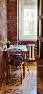 a dining room with a table and chairs and a window at Deivido apartamentai Šiauliuose in Šiauliai