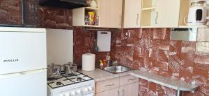 a small kitchen with a sink and a stove at Deivido apartamentai Šiauliuose in Šiauliai