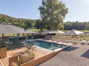 a swimming pool with tables and chairs and umbrellas at Agriturismo La Nevera in Lanzo dʼIntelvi