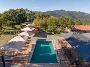 a view of a swimming pool with umbrellas at Agriturismo La Nevera in Lanzo dʼIntelvi