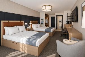 a hotel room with two beds and a desk at Stonebridge Inn in Snowmass Village