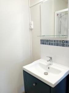 a bathroom with a white sink and a mirror at oiseau bleu in Dieppe