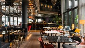 un ristorante con tavoli, sedie e finestre di Ruby Lilly Hotel Munich by IHG a Monaco